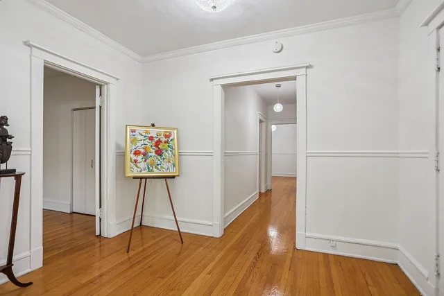 a view of a hallway with wooden floor and closet