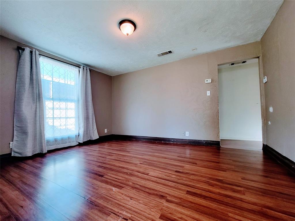 2004 Prairie Avenue Fort Worth, TX 76164 - Photo 17 of 21 an empty room with wooden floor and windows