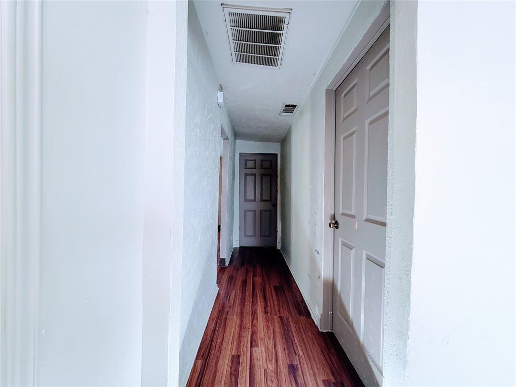 2004 Prairie Avenue Fort Worth, TX 76164 - Photo 18 of 21 a view of a hallway with wooden floor and a bathroom