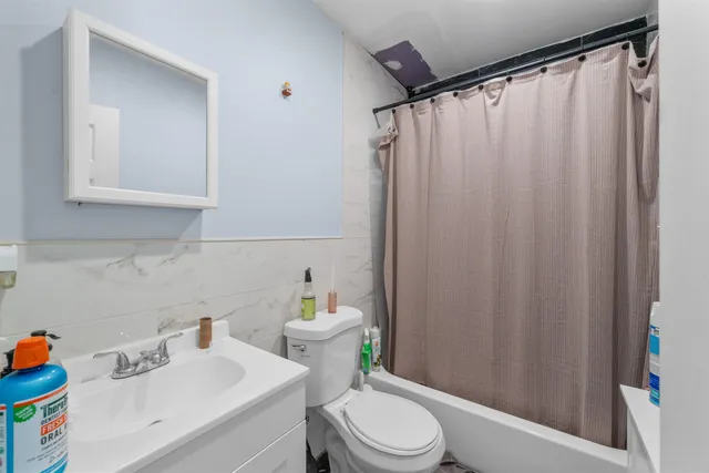 a bathroom with a sink a toilet and shower curtain