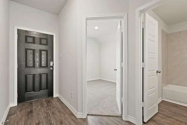 a view of a hallway with wooden floor and closet