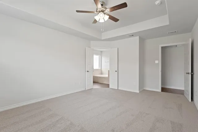 a view of an empty room and a ceiling fan window