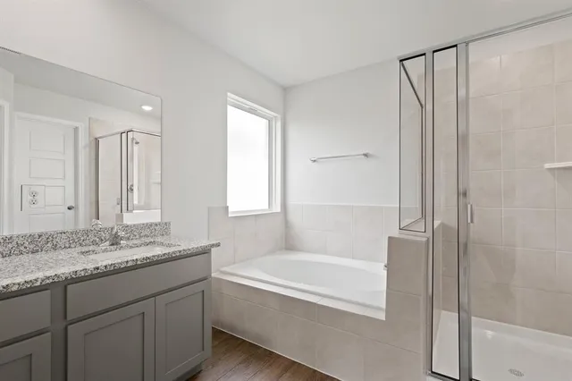 a bathroom with a granite countertop tub sink and mirror