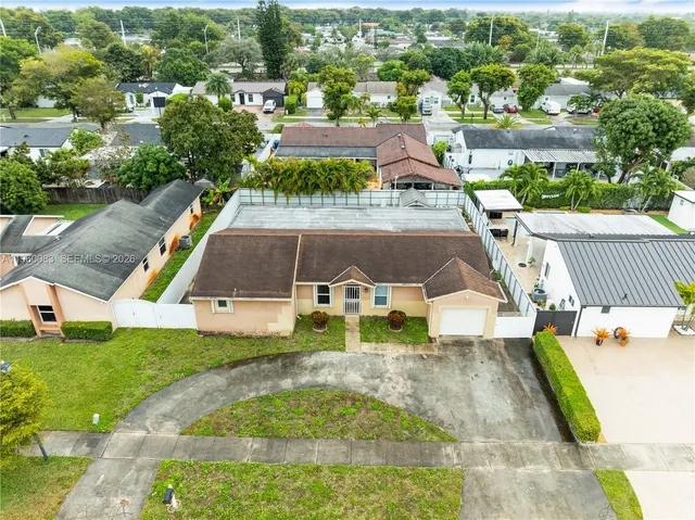 an aerial view of residential houses with outdoor space and swimming pool