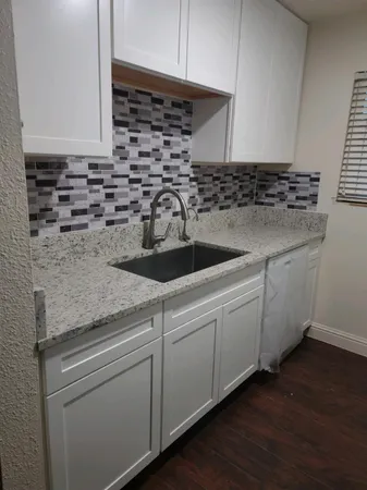 a kitchen with granite countertop a sink and a stove