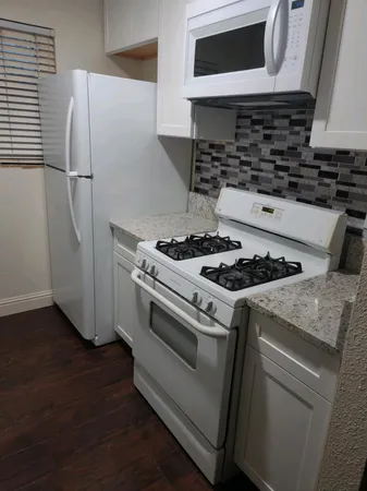 a white stove top oven sitting inside of a kitchen