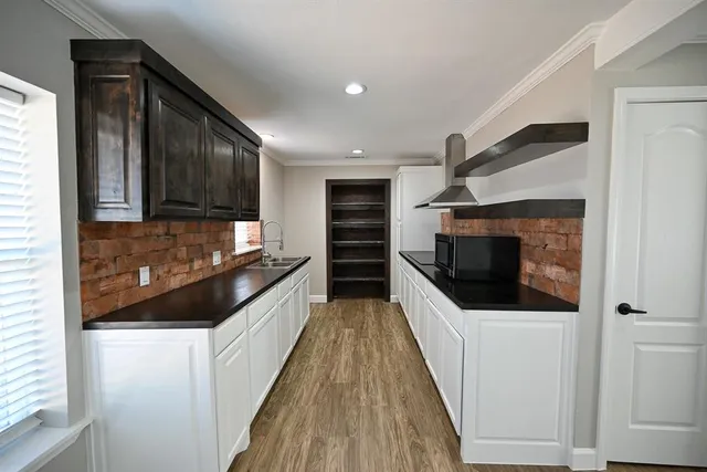 a kitchen with stainless steel appliances a microwave a stove and white cabinets