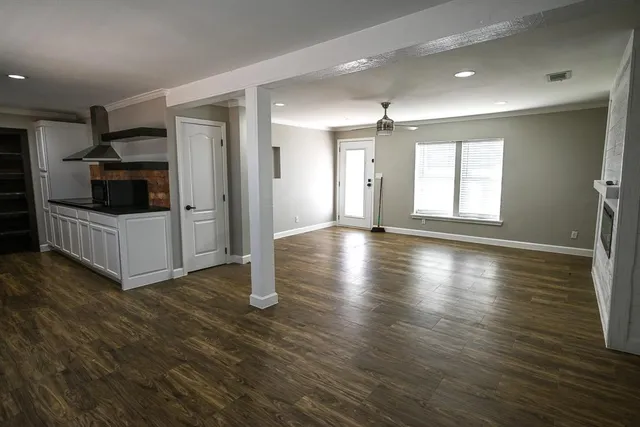 a view of a kitchen with wooden floor and electronic appliances