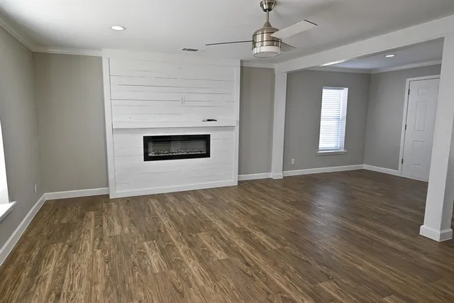 a view of an empty room with glass door and wooden floor