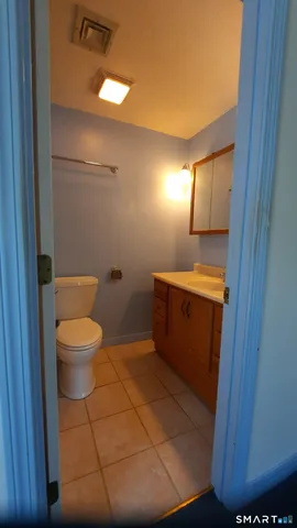 a bathroom with a toilet a sink and mirror