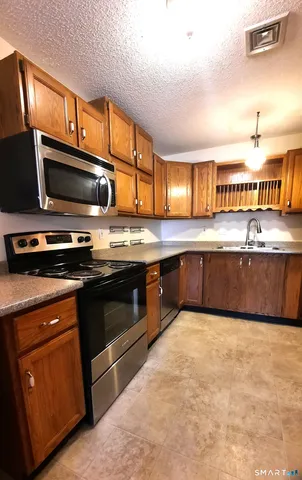 a kitchen with stainless steel appliances granite countertop a stove microwave and sink