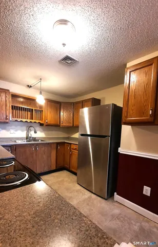 a kitchen with stainless steel appliances granite countertop a refrigerator a sink and a stove