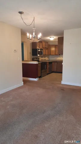 a open kitchen with a refrigerator a sink dishwasher a oven and a dining table with wooden floor