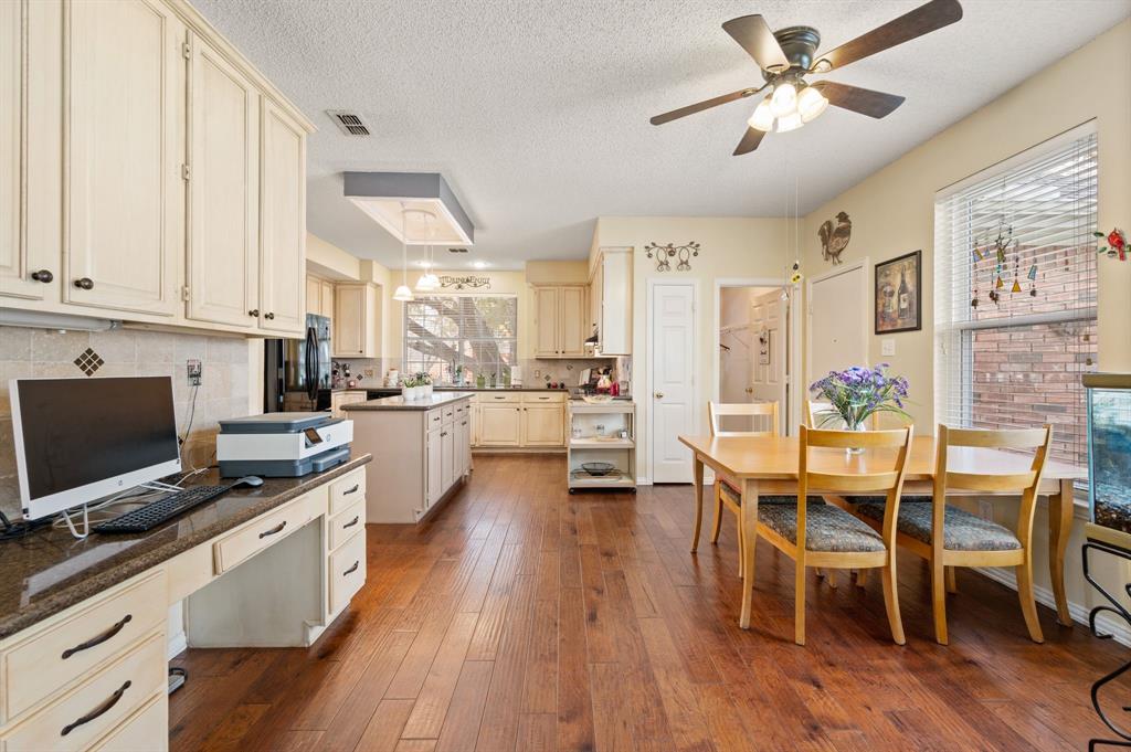 2156 Sandell Drive Grapevine, TX 76051 - Photo 14 of 40 a kitchen with a table chairs refrigerator and cabinets