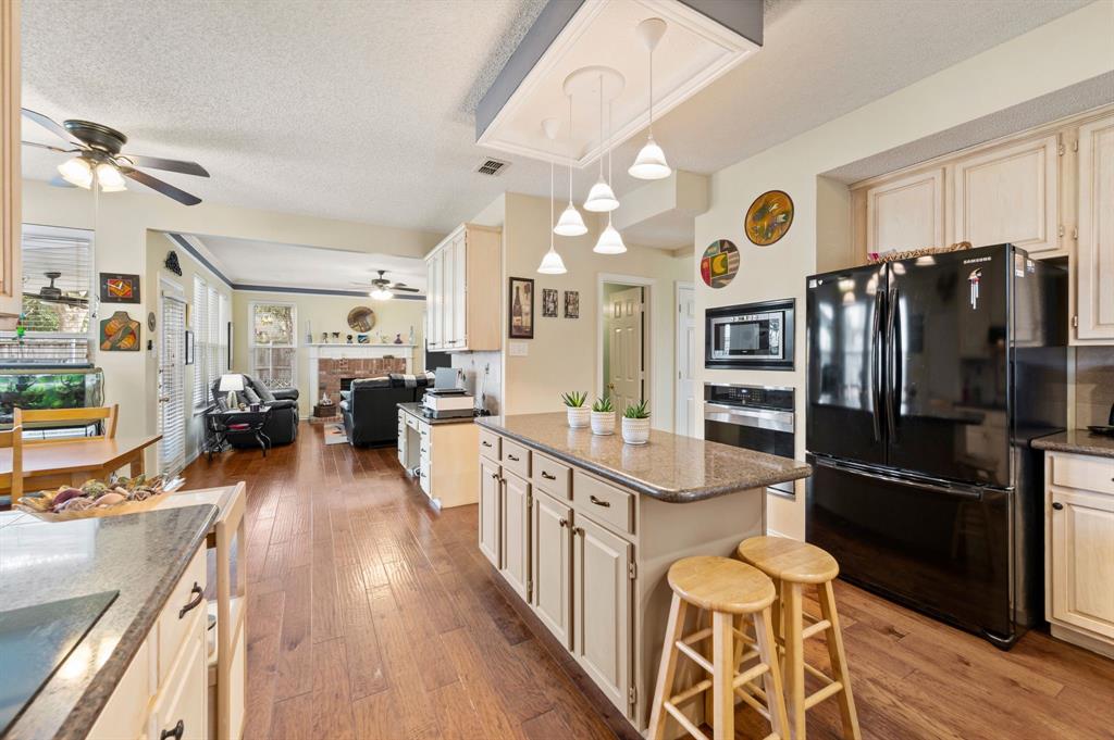 2156 Sandell Drive Grapevine, TX 76051 - Photo 16 of 40 a kitchen with stainless steel appliances a refrigerator and a stove top oven