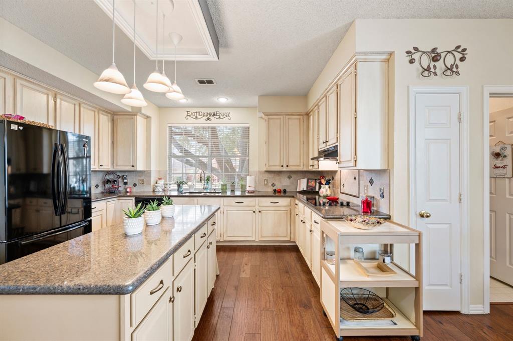 2156 Sandell Drive Grapevine, TX 76051 - Photo 17 of 40 a kitchen with a stove a sink and a refrigerator