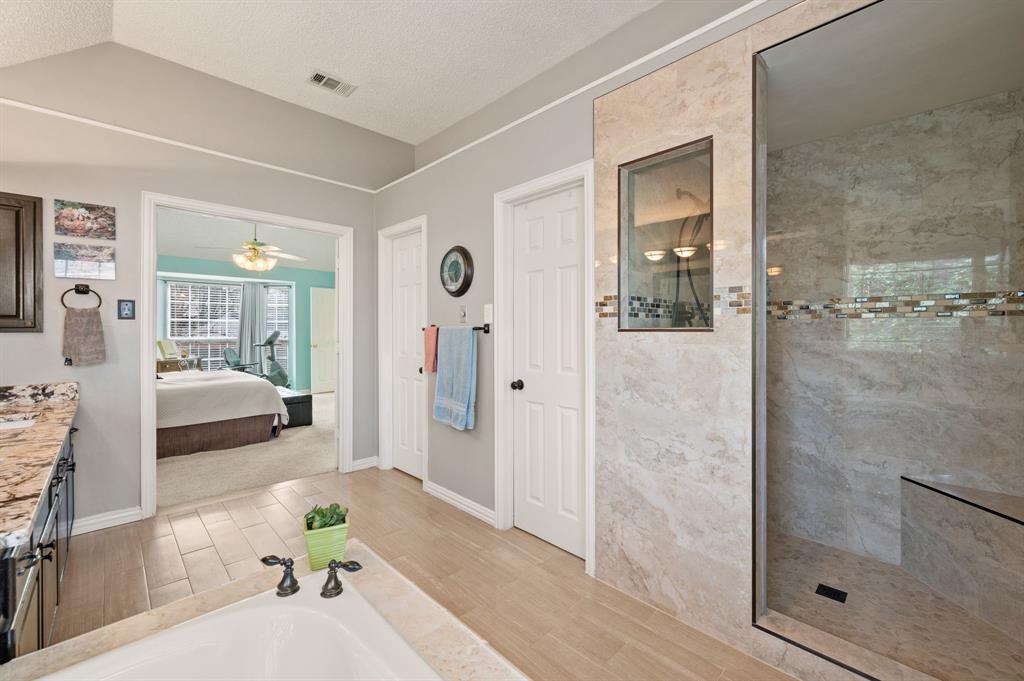 2156 Sandell Drive Grapevine, TX 76051 - Photo 26 of 40 a bathroom with a tub shower and mirror