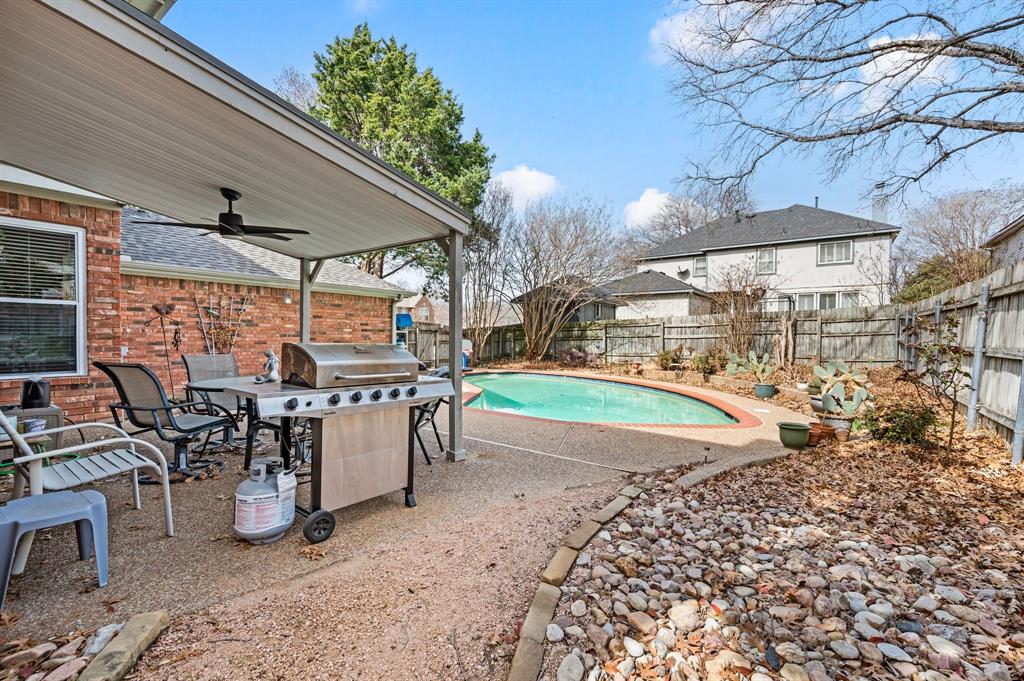 2156 Sandell Drive Grapevine, TX 76051 - Photo 32 of 40 a view of a patio with table and chairs under an umbrella