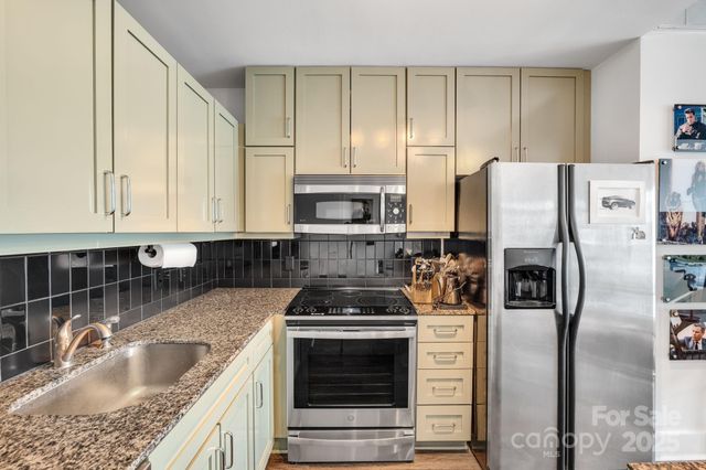 a kitchen with a table chairs and refrigerator