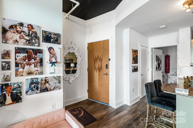 a kitchen with stainless steel appliances granite countertop a refrigerator a stove a sink a dining table and chairs with wooden floor