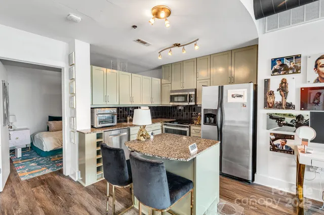 a kitchen with granite countertop a sink stove and refrigerator