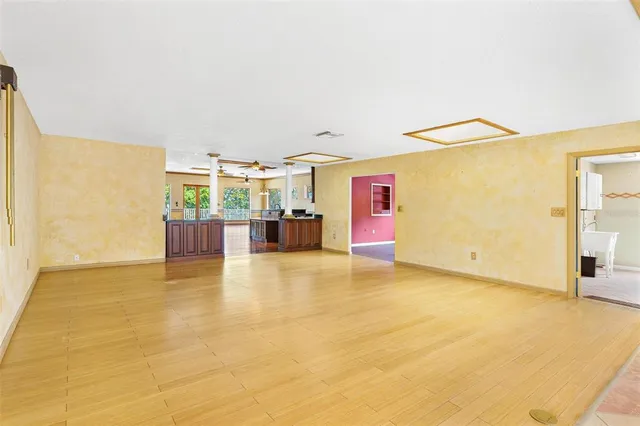 a living room with couches and pool view with wooden floor