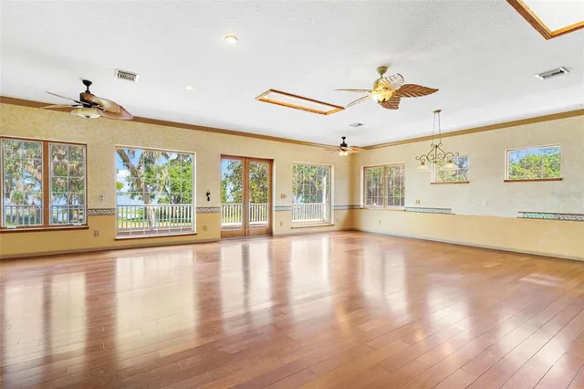 a view of a livingroom with wooden floor and a ceiling fan