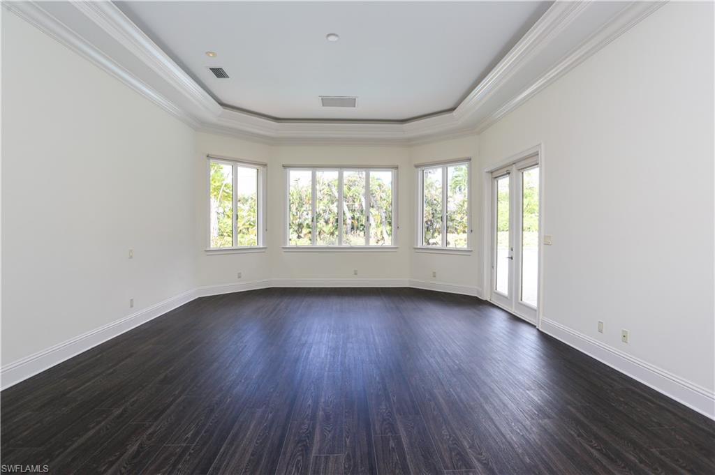 823 Cassena Road Naples, FL 34108 - Photo 20 of 50 an empty room with wooden floor and windows