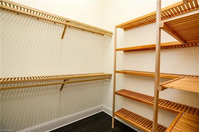 a view of walk in closet with clothes and shoes