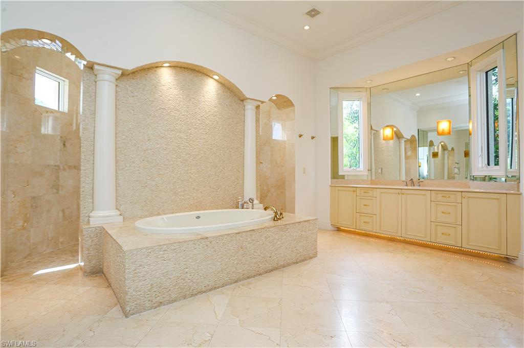 823 Cassena Road Naples, FL 34108 - Photo 23 of 50 a spacious bathroom with a tub double vanity and a mirror