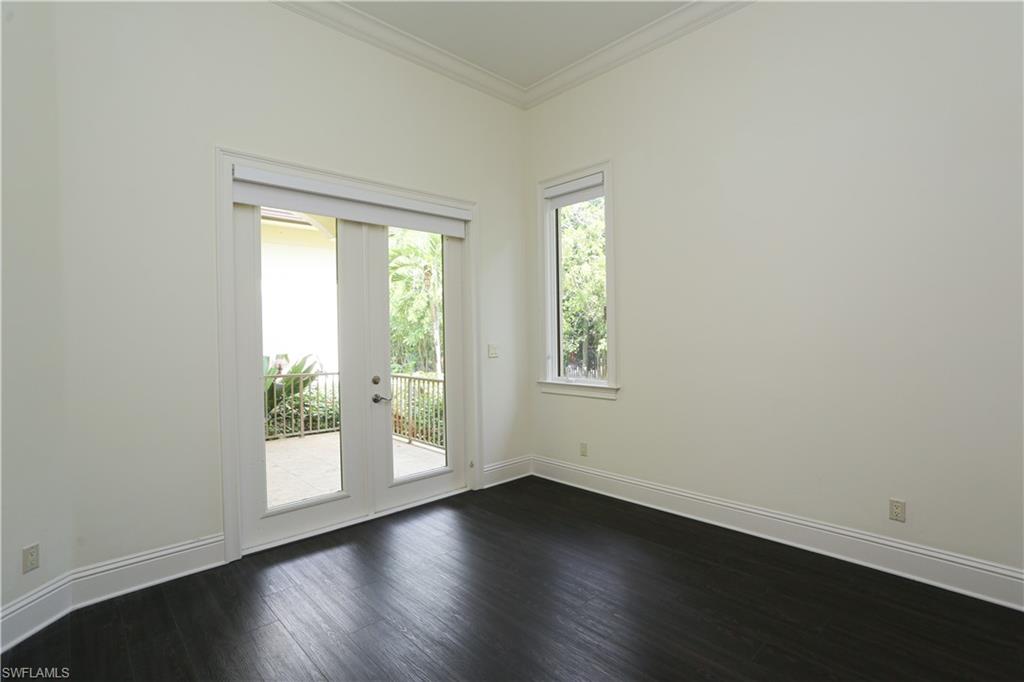 823 Cassena Road Naples, FL 34108 - Photo 28 of 50 an empty room with wooden floor and windows