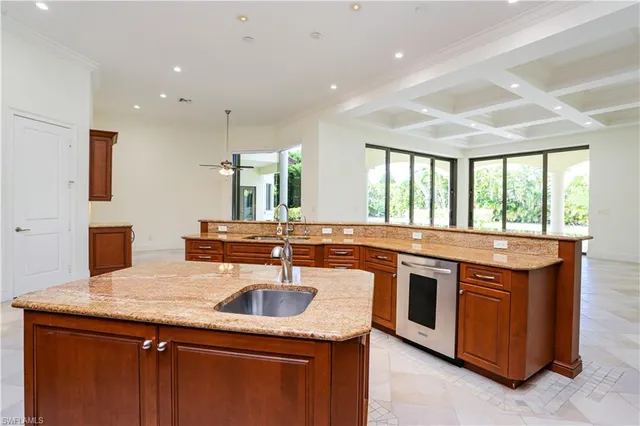 a kitchen with stainless steel appliances granite countertop a sink and a large window