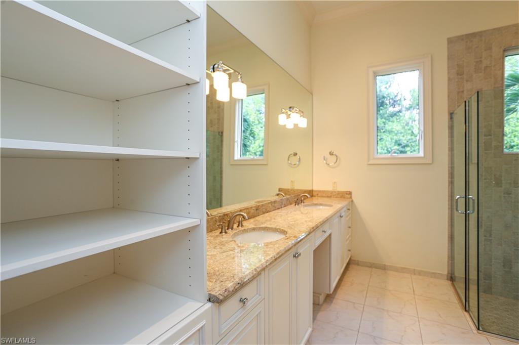 823 Cassena Road Naples, FL 34108 - Photo 38 of 50 a bathroom with a granite countertop sink and a mirror