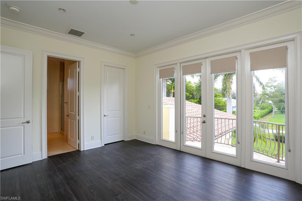 823 Cassena Road Naples, FL 34108 - Photo 42 of 50 a view of an empty room with wooden floor and a window