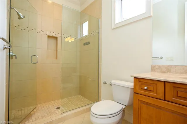 a bathroom with a granite countertop shower a toilet and a sink
