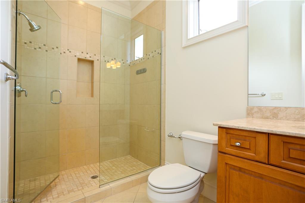 823 Cassena Road Naples, FL 34108 - Photo 47 of 50 a bathroom with a granite countertop shower a toilet and a sink