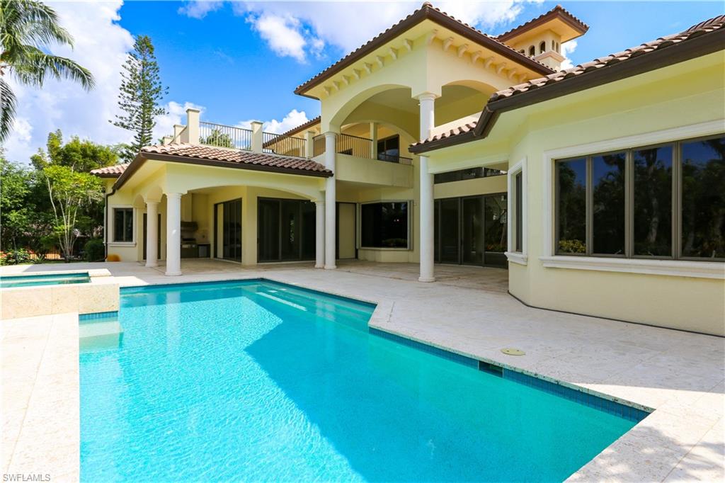 823 Cassena Road Naples, FL 34108 - Photo 9 of 50 a view of a white house with a swimming pool and porch