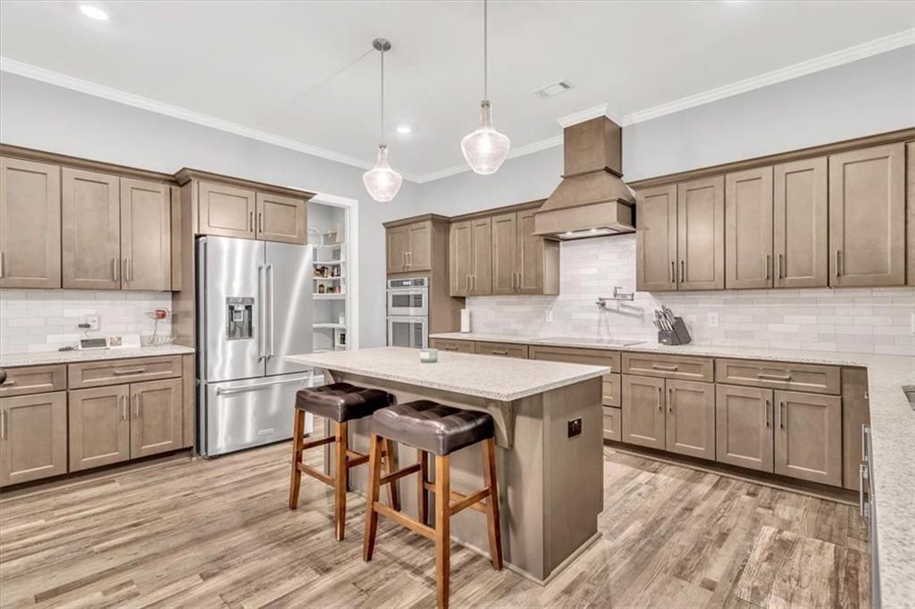 590 Eskew Road McDonough, GA 30252 - Photo 17 of 59 a kitchen with stainless steel appliances granite countertop a kitchen island hardwood floor sink stove and wooden cabinets