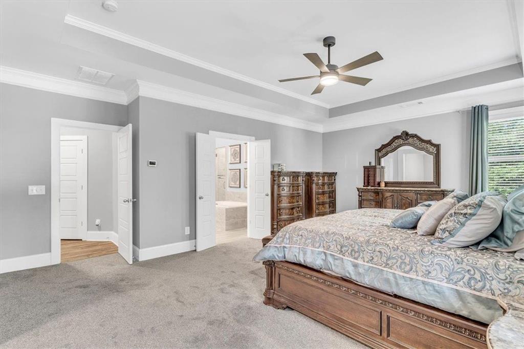 590 Eskew Road McDonough, GA 30252 - Photo 32 of 59 a bedroom with a large bed and a chandelier