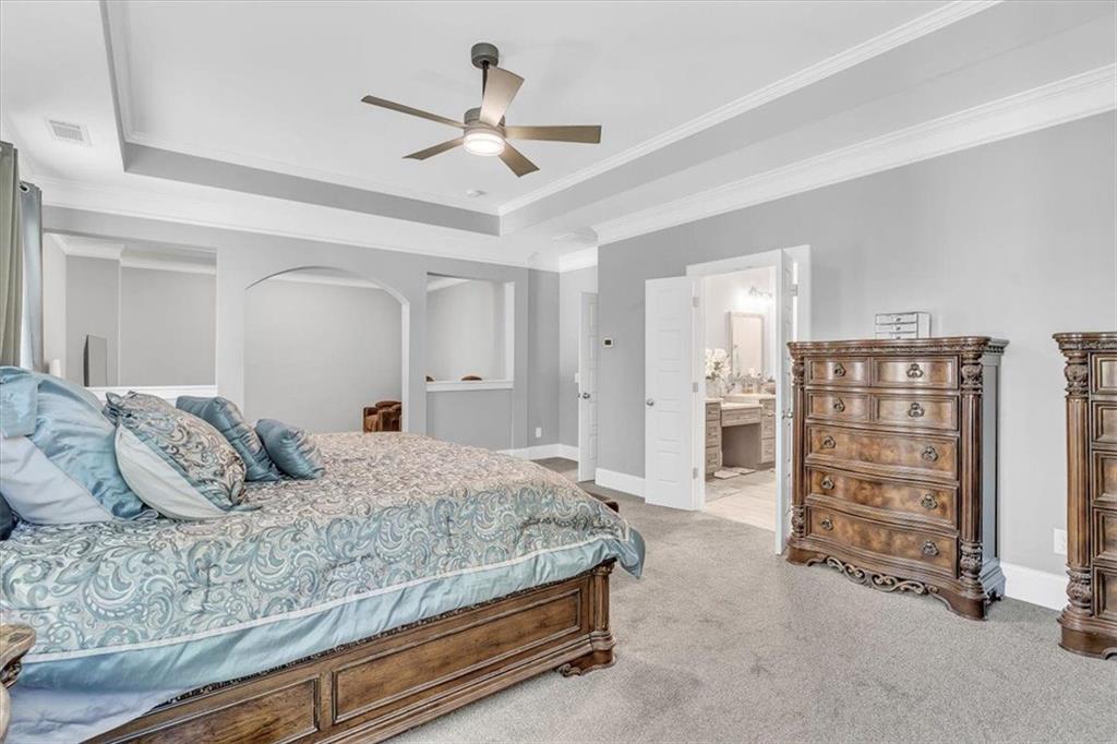 590 Eskew Road McDonough, GA 30252 - Photo 33 of 59 a bedroom with a large bed and a chandelier