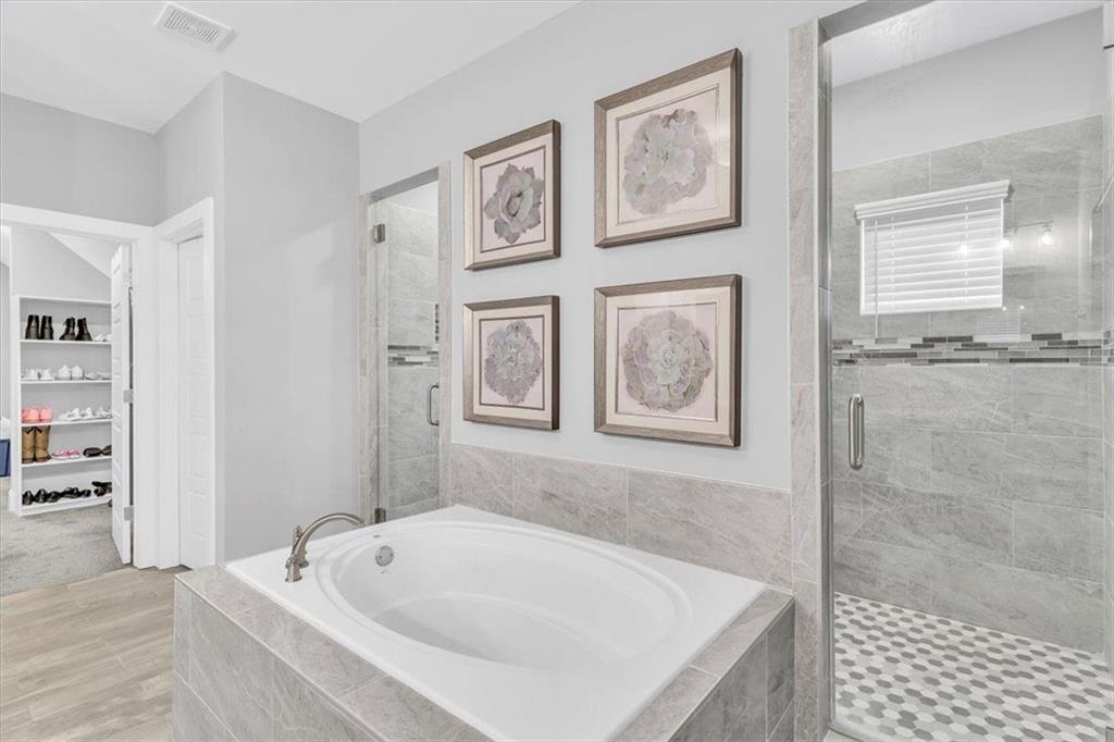 590 Eskew Road McDonough, GA 30252 - Photo 39 of 59 a bathroom with a tub a window and a shower