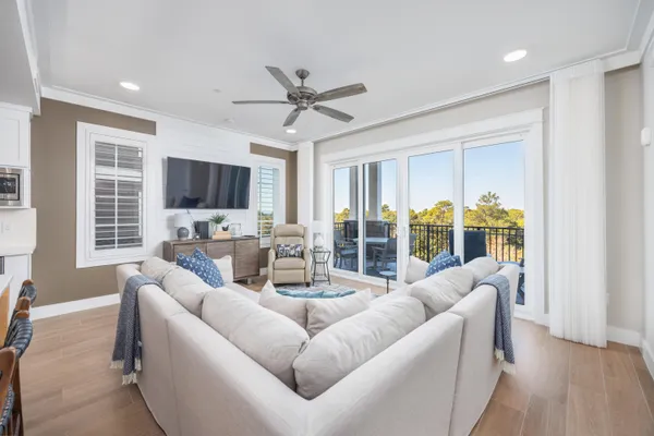 a living room with furniture and a flat screen tv with wooden floor