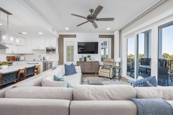a living room with furniture kitchen view and a large window