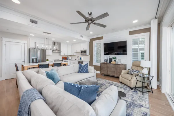 a living room with furniture kitchen view and a flat screen tv