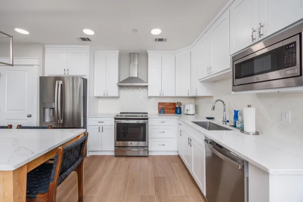 a kitchen with stainless steel appliances a stove a sink a refrigerator and cabinets