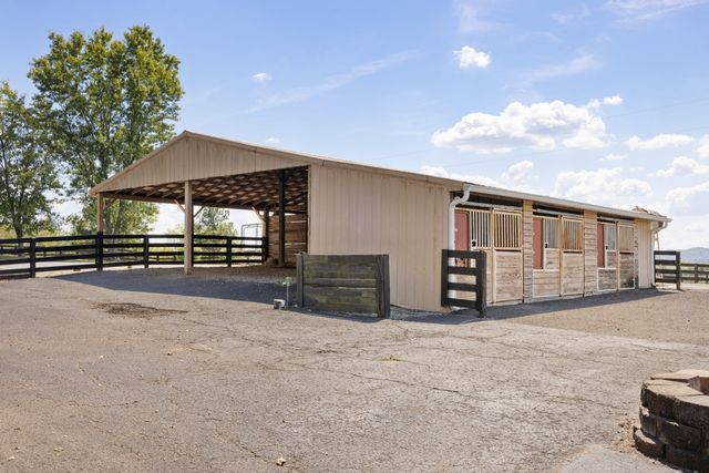a view of a big house with a big yard and large trees