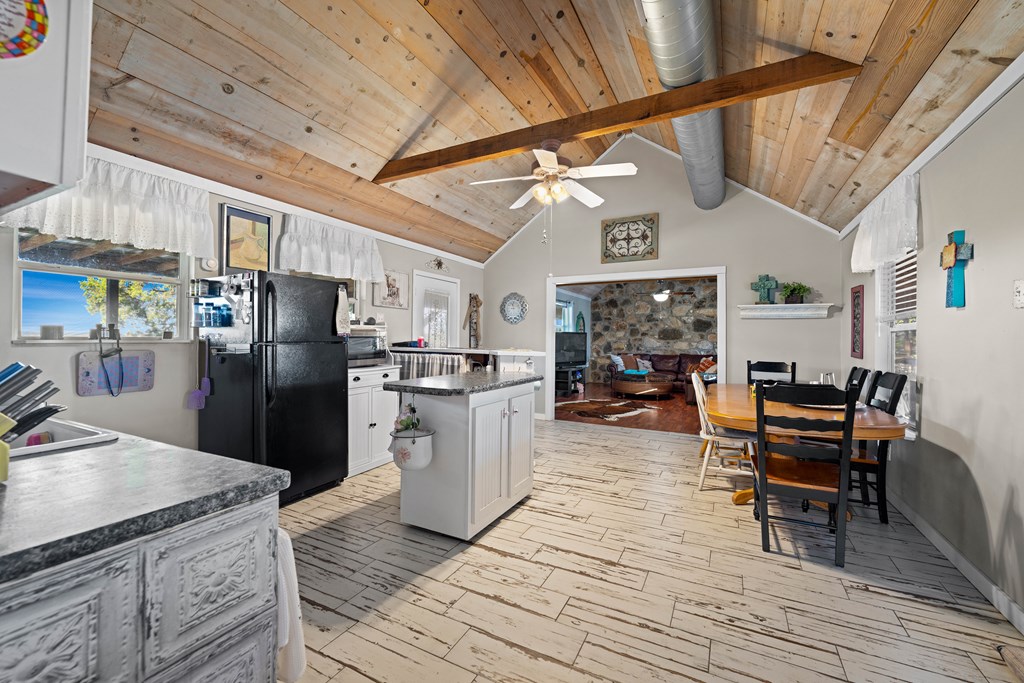 917 Bear Springs Road Mason, TX 76856 - Photo 23 of 38 a kitchen with stainless steel appliances granite countertop a refrigerator a stove top oven a dining table and chairs with wooden floor