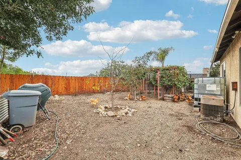 a view of a backyard with table and chairs and wooden fence