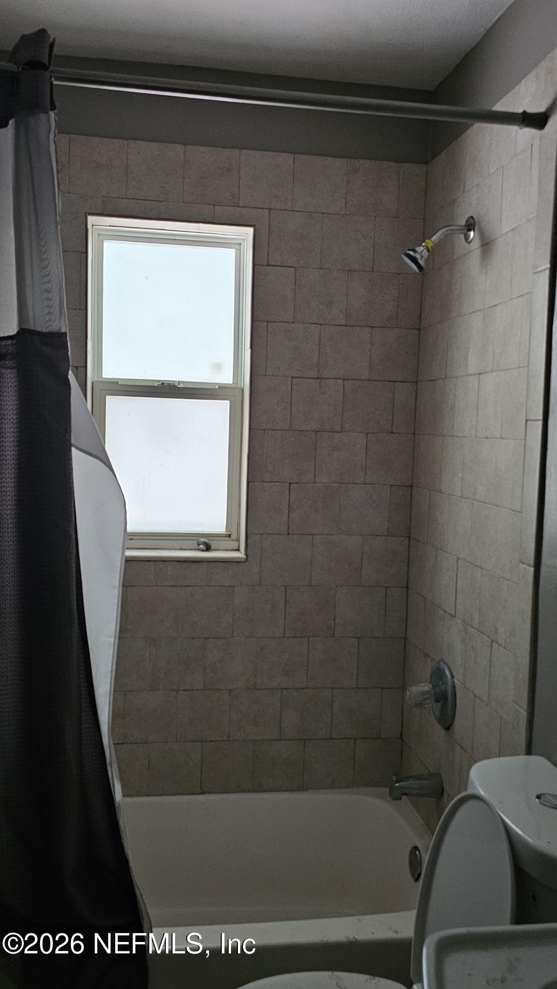 2727 North N Davis Rd Street Jacksonville, FL 32206 - Photo 22 of 31 a bathroom with a bath tub and a window