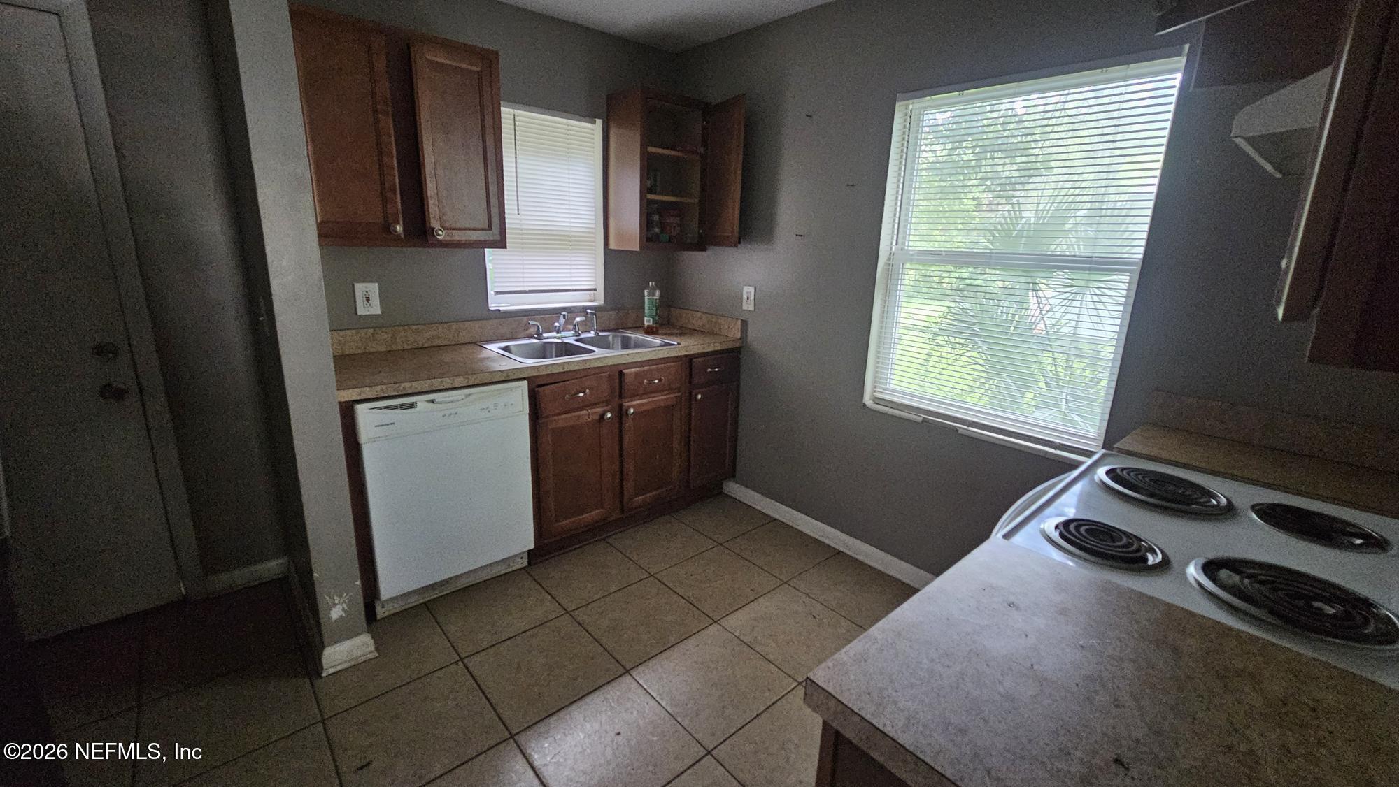 2727 North N Davis Rd Street Jacksonville, FL 32206 - Photo 29 of 31 a kitchen with a stove a sink and a window